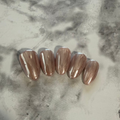 Shell inspired nails that are pink and cream with a stripy design and a shimmery chrome top